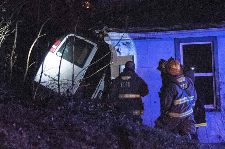 Fredericktown firefighters inspect a crash scene involving a cargo van and a house Monday in Fredericktown. Chase R. Weaver, 29, Fredericktown, was northbound on Mount Vernon Avenue when he went off the road, clipping the house. Ohio State Highway Patrol made an arrest after giving field sobriety tests to the driver. Weaver suffered minor injuries and was charged with felony OVI. The house was unoccupied.  (Joshua Morrison / Mount Vernon News)